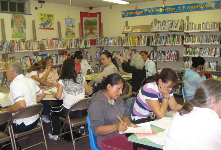 Adult learners studying together at a table during an adult education class